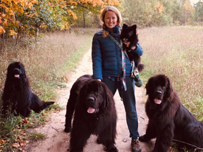 woman-with-three-black-newfoundlands-and-black-pomeranian